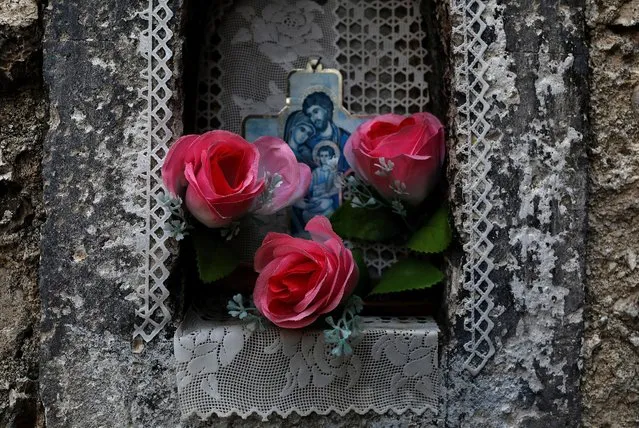 A cross and fake flowers are seen in a wall in the town of Castel del Monte, in the province of L'Aquila in Abruzzo, inside the national park of the Gran Sasso e Monti della Laga, Italy, September 9, 2016. (Photo by Siegfried Modola/Reuters)