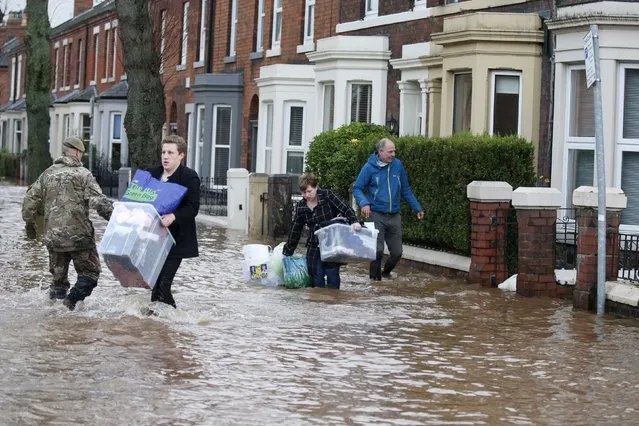 Residents carry their belongings through flood waters in the Warwick Road area of Carlisle, Britain December 6, 2015. (Photo by Phil Noble/Reuters)