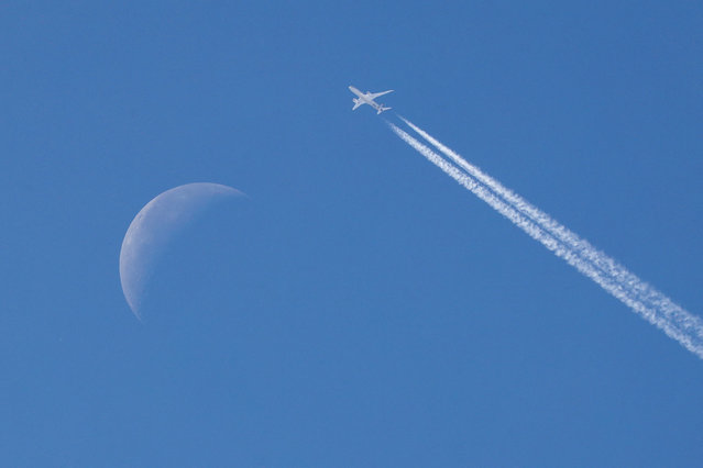 A passenger plane flies in the sky past the moon in the background over Belgrade, Serbia on September 16, 2025. (Photo by Fedja Grulovic/Reuters)