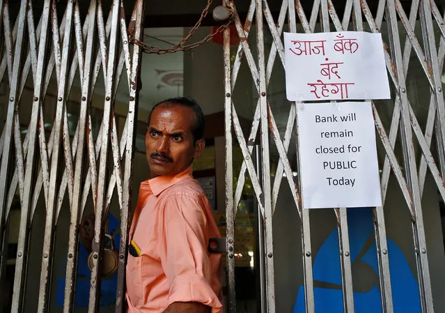 A man walks out of a closed bank in Mumbai, India, November 9, 2016. People are queuing up outside banks across India to exchange 500 and 1,000 rupee notes after they were withdrawn as part of anti-corruption measures. Indians will be able to exchange their old notes, which stopped being legal tender at midnight on Tuesday, for new ones at banks until 30 December. The surprise move is part of a government crackdown on corruption and illegal cash holdings. Banks were shut on Wednesday to allow them enough time to stock new notes. There are also limits on cash withdrawals from ATMs. The BBC's Yogita Limaye in Mumbai says there have been chaotic scenes outside many banks. (Photo by Danish Siddiqui/Reuters)
