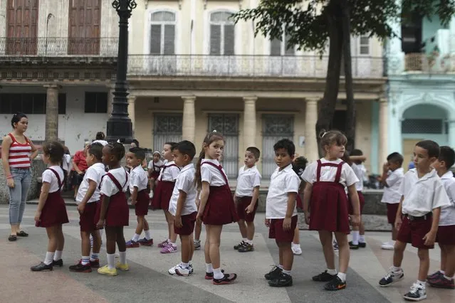 Kayla Hernandez, 5 (C), looks on school activities in downtown Havana January 20, 2015. (Photo by Alexandre Meneghini/Reuters)