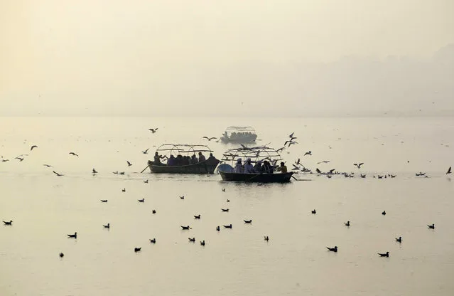 Devotees take ride on boats on river Yamuna on a winter morning in Allahabad, India, December 1, 2015. (Photo by Jitendra Prakash/Reuters)