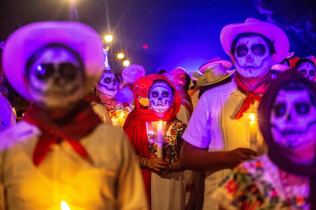 People with painted faces and clad in regional Mesrizo clothing take part in a procession representing The Walk of the Souls, which is the arrival of the spirits according to the Mayan worldview, as part of observances for the Day of the Dead in Merida, Mexico's Yucatan state on October 31, 2024. (Photo by Hugo Borges/AFP Photo)