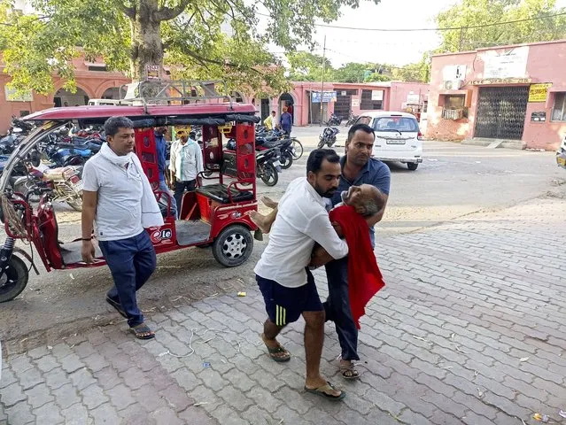 An elderly man is carried to a hospital in Ballia district, in northern Uttar Pradesh state, India, Sunday, June 18, 2023. Swaths of two of India's most populous states are under a grip of sever heat leaving dozens of people dead in several days as authorities issue a warning to residents over 60 and others with ailments to stay indoors during the daytime. (Photo by AP Photo/Stringer)