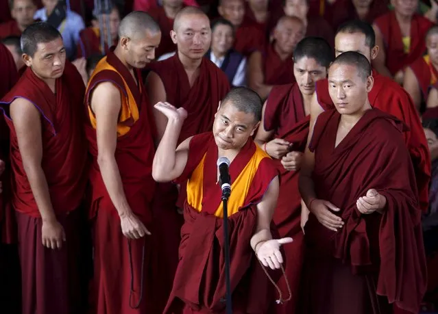 A Buddhist monk gestures as he participates in a religious debate before the start of the Jangchup Lamrim teachings conducted by the Tibetan spiritual leader the Dalai Lama (unseen) at the Tashi Lhunpo Monastery in Bylakuppe in the southern state of Karnataka, India, December 20, 2015. (Photo by Abhishek N. Chinnappa/Reuters)