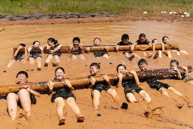 Children are training during the “Tactical Quagmire” program at a military summer camp in Hefei, Anhui Province, China on July 5, 2023. (Photo by Costfoto/NurPhoto via Getty Images)