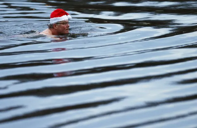 A swimmer takes a dip in the Serpentine River before the annual Christmas Day Peter Pan Cup handicap race in Hyde Park, London, December 25, 2015. (Photo by Andrew Winning/Reuters)