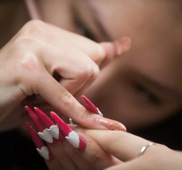 Competitor Cindy Yuen works on the nails of a model at the Canada Nail Cup in Vancouver, Monday, February 16, 2015. Nail artists competed in multiple categories at the event, which according to organizers is the only nail competition in the country. (Photo by Darryl Dyck/AP Photo/The Canadian Press)