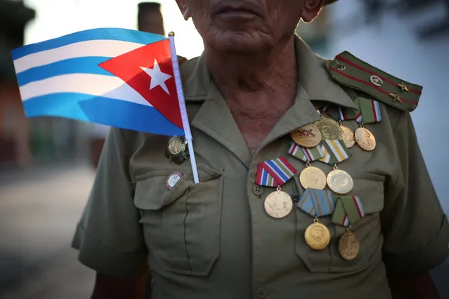 Elias waits along a street for the ashes of Fidel Castro to pass, during a three-day journey to the eastern city of Santiago de Cuba, in Bayamo, Cuba, December 2, 2016. (Photo by Edgard Garrido/Reuters)