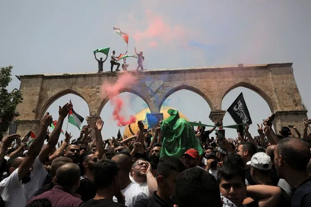 Palestinians wave national flags in front of the Dome of the Rock in the al-Aqsa mosque complex in Jerusalem, Friday, May 21, 202, as a cease-fire took effect between Hamas and Israel after an 11-day war. (Photo by Mahmoud Illean/AP Photo)