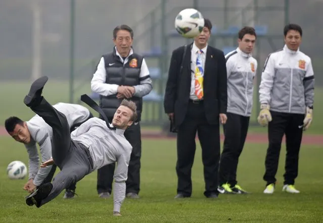 Former England captain David Beckham slips as he free kicks at a sports field during his visit in Wuhan, Hubei province, in this March 23, 2013 file photo. (Photo by Reuters/Stringer)