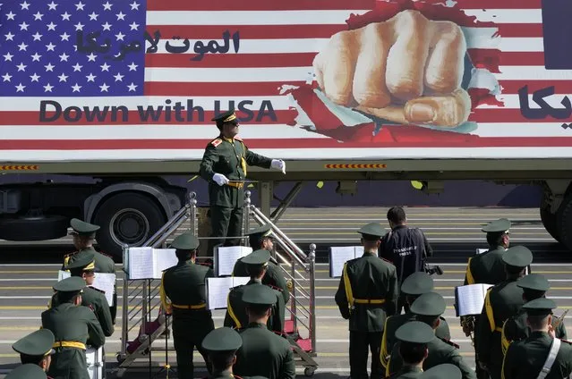 An anti-U.S. banner is carried on a truck in an annual military parade marking anniversary of the beginning of war against Iran by former Iraqi Dictator Saddam Hussein, in front of the shrine of the late revolutionary founder Ayatollah Khomeini, just outside Tehran, Iran, Friday, September 22, 2023. (Photo by Vahid Salemi/AP Photo)
