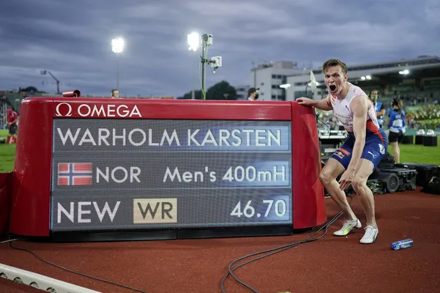 Norway's Karsten Warholm celebrates in front of the scoreboard after running 46.70 seconds to set a new men's 400m hurdles world record at the Diamond League meeting in Oslo, Norway Thursday July 1, 2021. (Photo by Fredrik Hagen/NTB via AP Photo)