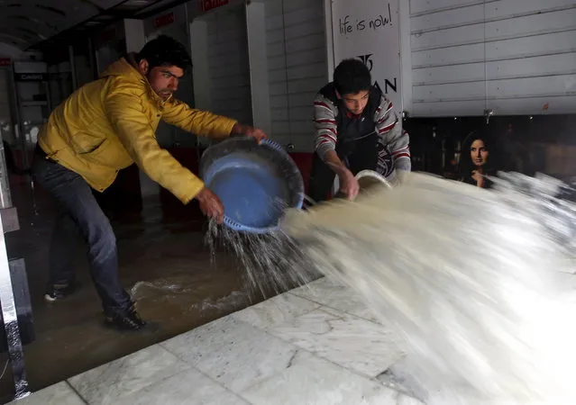 Men remove water from a water-logged shop after incessant rains in Srinagar March 29, 2015. (Photo by Danish Ismail/Reuters)
