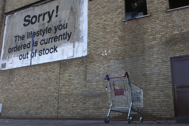 A new work by Banksy, in the form of a billboard, adorns a wall near the Canary Wharf financial district in London, December 22, 2011. (Photo by Finbarr O'Reilly/Reuters)