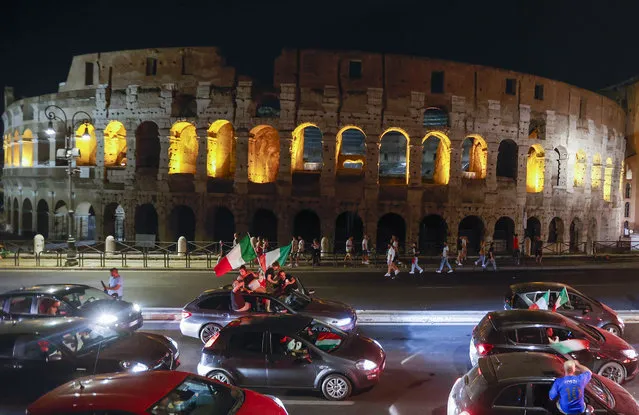 Italy's fans celebrate in front of the ancient Colosseum in Rome, Monday, July 12, 2021, after Italy beat England to win the Euro 2020 soccer championships in a final played at Wembley stadium in London. Italy beat England 3-2 in a penalty shootout after a 1-1 draw. (Photo by Riccardo De Luca/AP Photo)