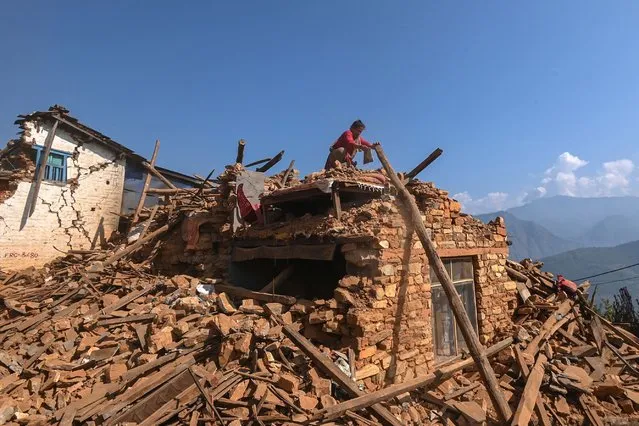 A survivor searches for belongings through the ruins of her damaged house following an earthquake in Khalanga of Jajarkot district on November 6, 2023. At least 157 people were killed in isolated western districts of the Himalayan country when the 5.6-magnitude earthquake hit late November 3. (Photo by Prakash Mathema/AFP Photo)