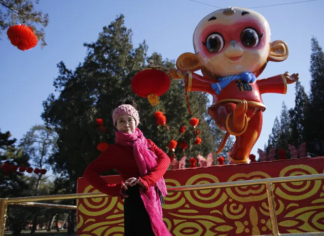 A woman poses in front of a monkey-shaped installation set up for celebrating the upcoming Chinese Lunar New Year of the Monkey ahead of the temple fair in Ditan Park, also known as the Temple of Earth, in Beijing, China, February 5, 2016. (Photo by Kim Kyung-Hoon/Reuters)