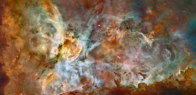 This false-color image made by the NASA/ESA Hubble Space Telescope shows the Carina Nebula. Outflowing winds and intense ultraviolet radiation from the large stars shape the material that is the last vestige of the giant cloud from which the stars were born. Red corresponds to sulfur, green to hydrogen, and blue to oxygen emission. (Photo by NASA/ESA, N. Smith – University of California, Berkeley/Hubble Heritage Team (STScI/AURA) via AP Photo)