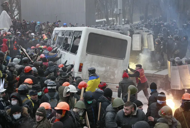Pro-European integration protesters attack a police van during a rally near government administration buildings in Kiev January 19, 2014. (Photo by Gleb Garanich/Reuters)
