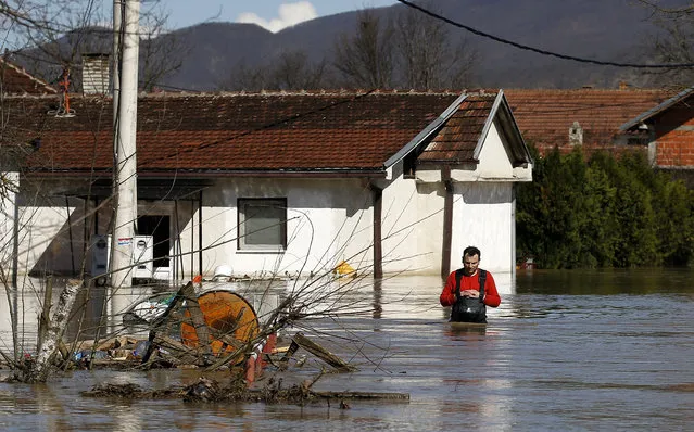 A man walks in front of a his flooded home in the village of Grdica, Serbia, Tuesday, March 8, 2016. Hundreds of people had to evacuate their homes, while hundreds of houses remained under threat, police said. In several villages and towns, entire areas have been left without electricity or water, and some schools canceled classes for the day. (Photo by Darko Vojinovic/AP Photo)