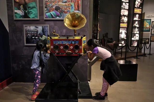 Girls watch still clips from a film on a bioscope inside the National Museum of Indian Cinema in Mumbai, February 19, 2019. (Photo by Francis Mascarenhas/Reuters)