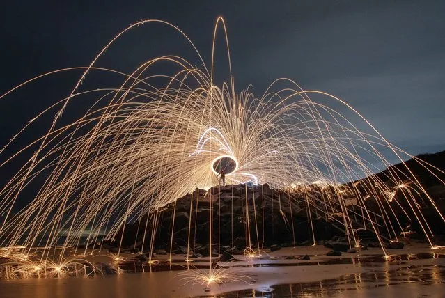 Light painting on the beach at Walton-on-the-Naze in Essex, UK on January 3, 2024, using burning steel wool spun around on a rope sending sparks flying during a 37-second exposure. (Photo by Kevin Jay/Picture Exclusive)