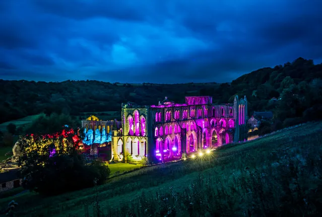 The remains of the 11-century abbey is bathed in coloured light before Illuminating Rievaulx, North Yorkshire, UK a three-night light and sound installation. (Photo by Danny Lawson/PA Wire)