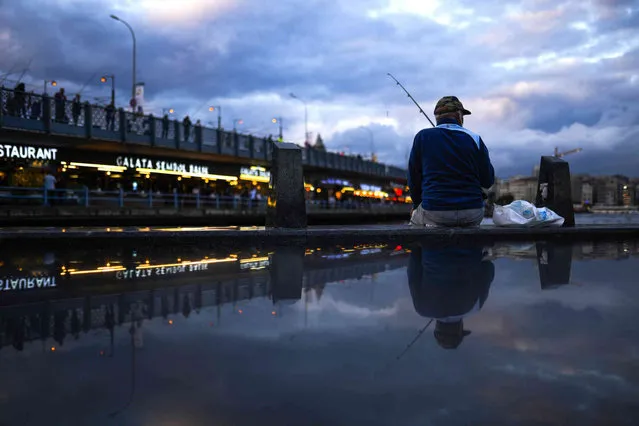 A fisherman casts his line into the Bosphorus next to Galata bridge in Istanbul, Turkey, Wednesday, September 29, 2021. (Photo by Francisco Seco/AP Photo)