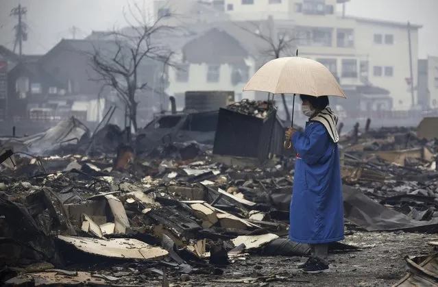 A woman looks at the burned-out marketplace by a fire following earthquakes in Wajima, Ishikawa prefecture, Japan Wednesday, January 3, 2024. (Photo by Kyodo News via AP Photo)