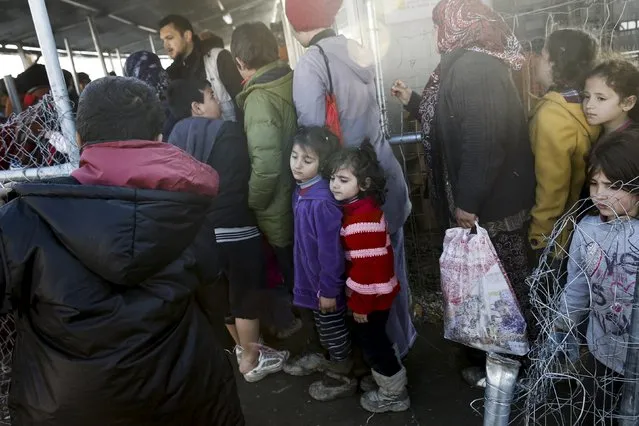 Two refugee girls (C) line up for a breakfast distribution at a makeshift camp for refugees and migrants at the Greek-Macedonian border near the village of Idomeni, Greece, March 19, 2016. (Photo by Alkis Konstantinidis/Reuters)