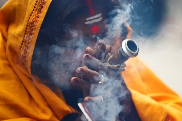 A Hindu holy woman smokes marijuana during the “Shivaratri” festival at the courtyard of the Pashupatinath Hindu temple in Katmandu, Nepal, Thursday, February 27, 2014. (Photo by Niranjan Shrestha/AP Photo)