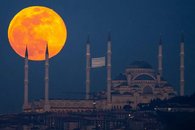 A full moon rises behind the Camlica mosque in Istanbul, Turkey, Saturday, February 24, 2024. (Photo by Emrah Gurel/AP Photo)