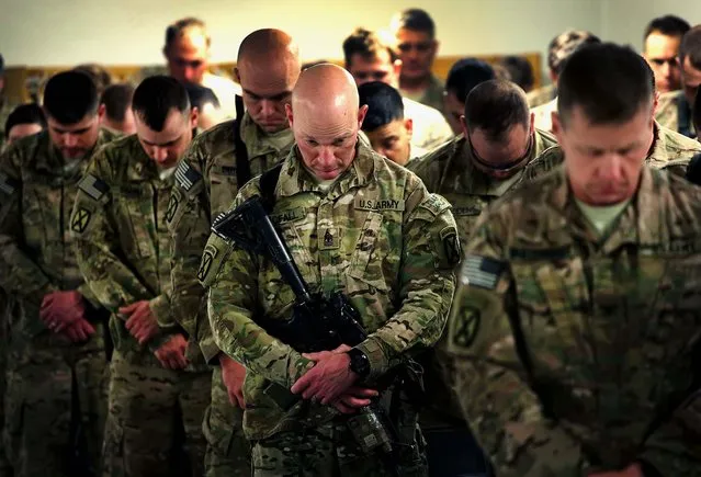 Soldiers with the U.S. Army's 3rd Brigade Combat Team, 10th Mountain Division pray during a ceremony to recognize newly promoted non-commissioned Officers on FOB Lightning near Gardez, Afghanistan, on March 21, 2014. The mission of the brigade is to advise and assist the Afghan National Army on nearby FOB Thunder. Most U.S. troops no longer undertake combat roles in Afghanistan. (Photo by Scott Olson/Getty Images)