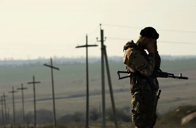A Ukrainian soldier stands guard outside a Ukrainian Army military camp set up on a field close to the Russian border in east Ukraine March 24, 2014. (Photo by Yannis Behrakis/Reuters)