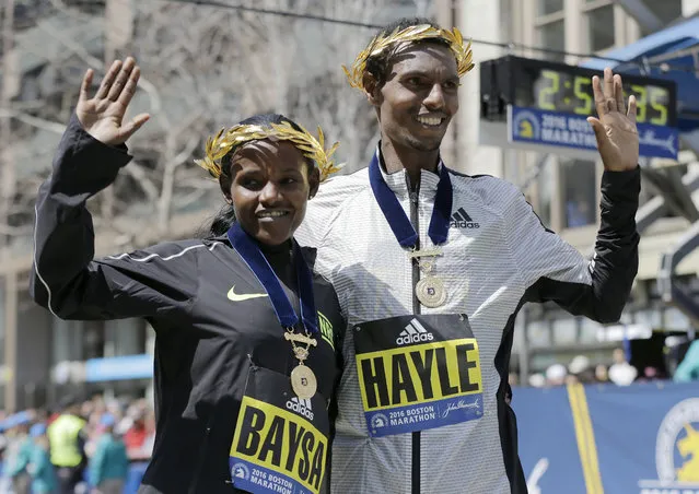 Atsede Baysa, left, and Lemi Berhanu Hayle, both of Ethiopia, pose for photos after they won the women's and men's divisions of the 120th Boston Marathon on Monday, April 18, 2016, in Boston. (Photo by Elise Amendola/AP Photo)