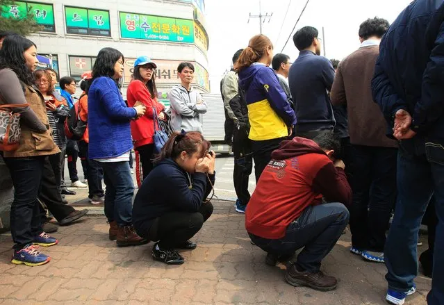 Parents wait at Danwon High School in Ansan, South Korea, after the ferry their children were riding in sank, April 16, 2014. (Photo by Ahn Young-joon/AP Photo)