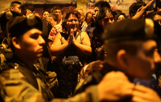 Relatives of inmates wait outside Lurigancho prison where a fire was reported according to the authorities, in Lima, Peru, March 19, 2017. (Photo by Sebastian Castaneda/Reuters)