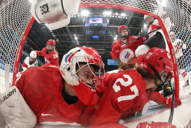 Russian Olympic Committee's goaltender Mariia Sorokina (foreground L) and teammate Veronika Korzhakova (foreground R) attempt to stop a shot by Switzerland's Phoebe Staenz (R) during the women's preliminary round group A match of the Beijing 2022 Winter Olympic Games ice hockey competition between players of Russia's Olympic Committee and Switzerland, at the National Indoor Stadium in Beijing on February 4, 2022. (Photo by Bruce Bennett/Reuters)