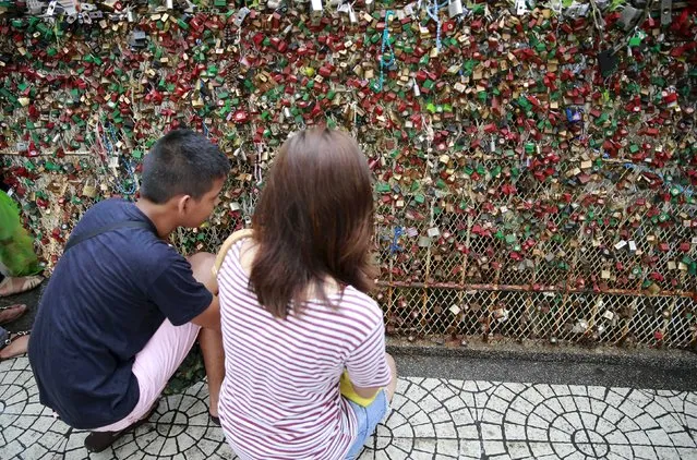 A couple puts a padlock on a fence as they pray for a lasting relationship and ask for blessings, in front of a Catholic church in Paranaque city, metro Manila, Philippines July 4, 2015. (Photo by Romeo Ranoco/Reuters)