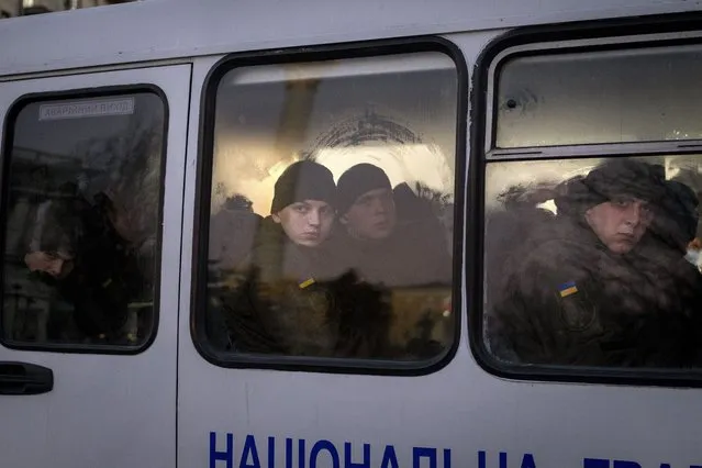 Members of National Guard of Ukraine look out of the window as they ride in a bus through the city of Kyiv, Monday, February 14, 2022. More NATO troops headed to Eastern Europe and some nations worked to move their citizens and diplomats out of Ukraine on Monday, as Germany's chancellor made a last-ditch attempt to head off a feared Russian invasion that some warn could be just days away. (Photo by Emilio Morenatti/AP Photo)