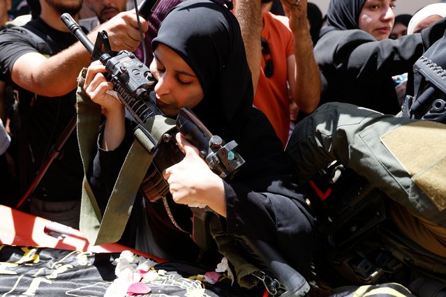 Haneen, sister of Mohammad Shehada who was killed in an Israeli airstrike, kisses his rifle during the funeral of four Palestinians in Nour Shams camp, in Tulkarm, in the Israeli-occupied West Bank on July 3, 2024. (Photo by Raneen Sawafta/Reuters)