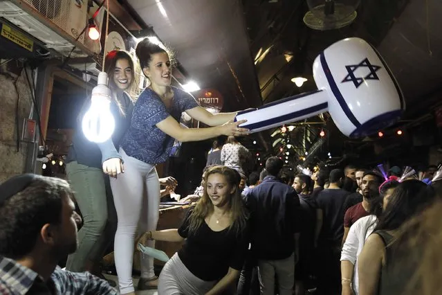 Israeli youths dance as they celebrate all night long Israel's 69th Independence Day in the Mahane Yehuda market at the centre of Jerusalem on May 2, 2017. (Photo by Menahem Kahana/AFP Photo)