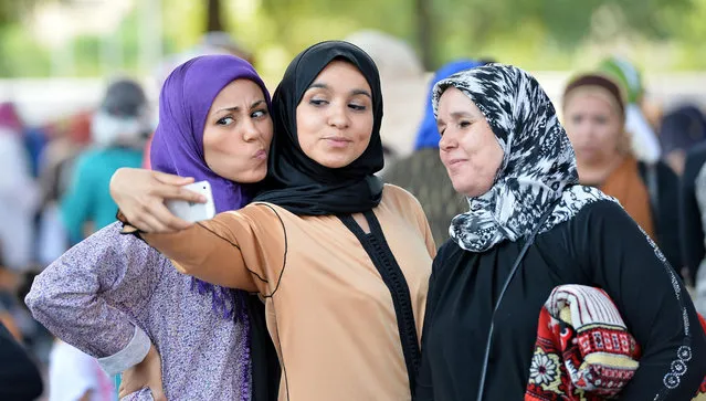 Women pose for a selfie as they attend Eid al-Fitr celebration in Turin, Italy, Friday, July 17, 2015. Millions of Muslims across the world are celebrating the Eid al-Fitr holiday, which marks the end of the month-long fast of Ramadan. (Photo by Alessandro Di Marco/ANSA via AP Photo)