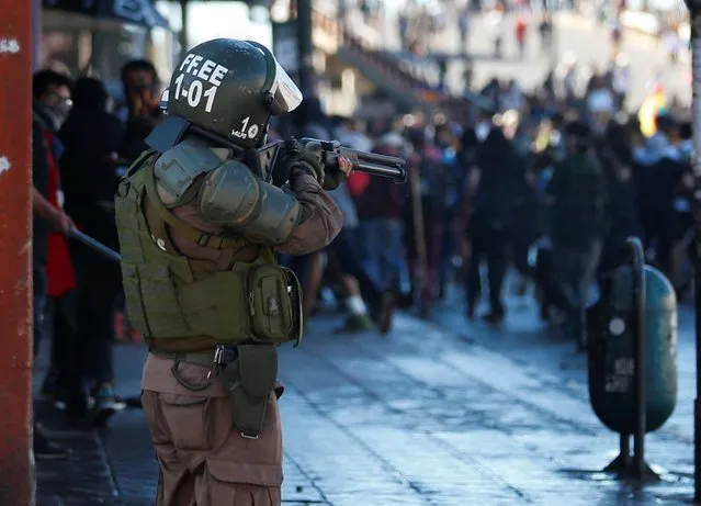 A member of the security forces aims his weapon during a protest against Chile's government in Valparaiso, Chile on October 28, 2019. (Photo by Rodrigo Garrido/Reuters)