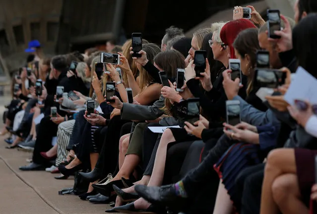 Audience members take photos with their phone cameras during the first runway show of Fashion Week Australia by local designer Dion Lee on the steps of the Sydney Opera House, in Sydney on May 14, 2017. (Photo by Jason Reed/Reuters)