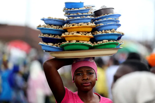 A girl hawks groundnuts arranged on a tray along a road in Nigeria's southwest city of Osogbo, August 11, 2014. (Photo by Akintunde Akinleye/Reuters)