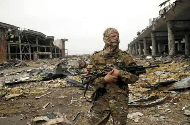 A member of the self-proclaimed Donetsk People's Republic forces stands guard near buildings destroyed during battles with Ukrainian armed forces, at Donetsk airport, Ukraine, June 1, 2016. (Photo by Alexander Ermochenko/Reuters)