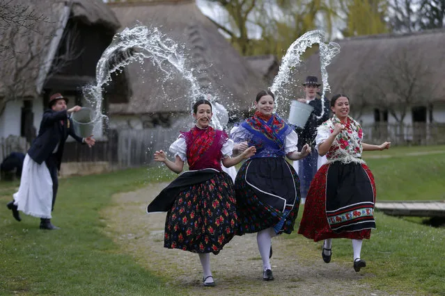 Women run as men throw water at them as part of traditional Easter celebrations, during a media presentation in Szenna April 3, 2015. Locals celebrate Easter with the traditional “watering of the girls”, a fertility ritual rooted in Hungarian tribes' pre-Christian past, going as far back as the second century after Christ. (Photo by Laszlo Balogh/Reuters)