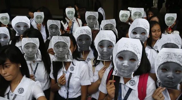 Students from an all-girls Catholic school, St. Scholastica's College, wear masks depicting kidnapped African school girls in Manila, June 27, 2014. (Photo by Erik De Castro/Reuters)